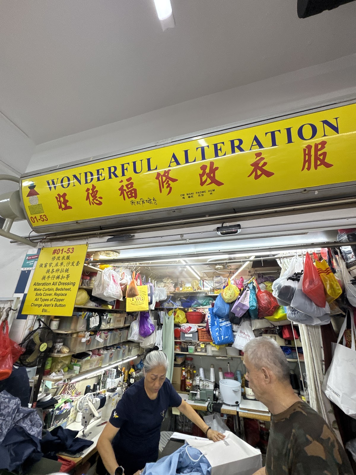 The Wonderful Alteration Store shopfront at Blk 127 Toa Payoh, with Ivy and Ah Wah at work under the yellow signboard