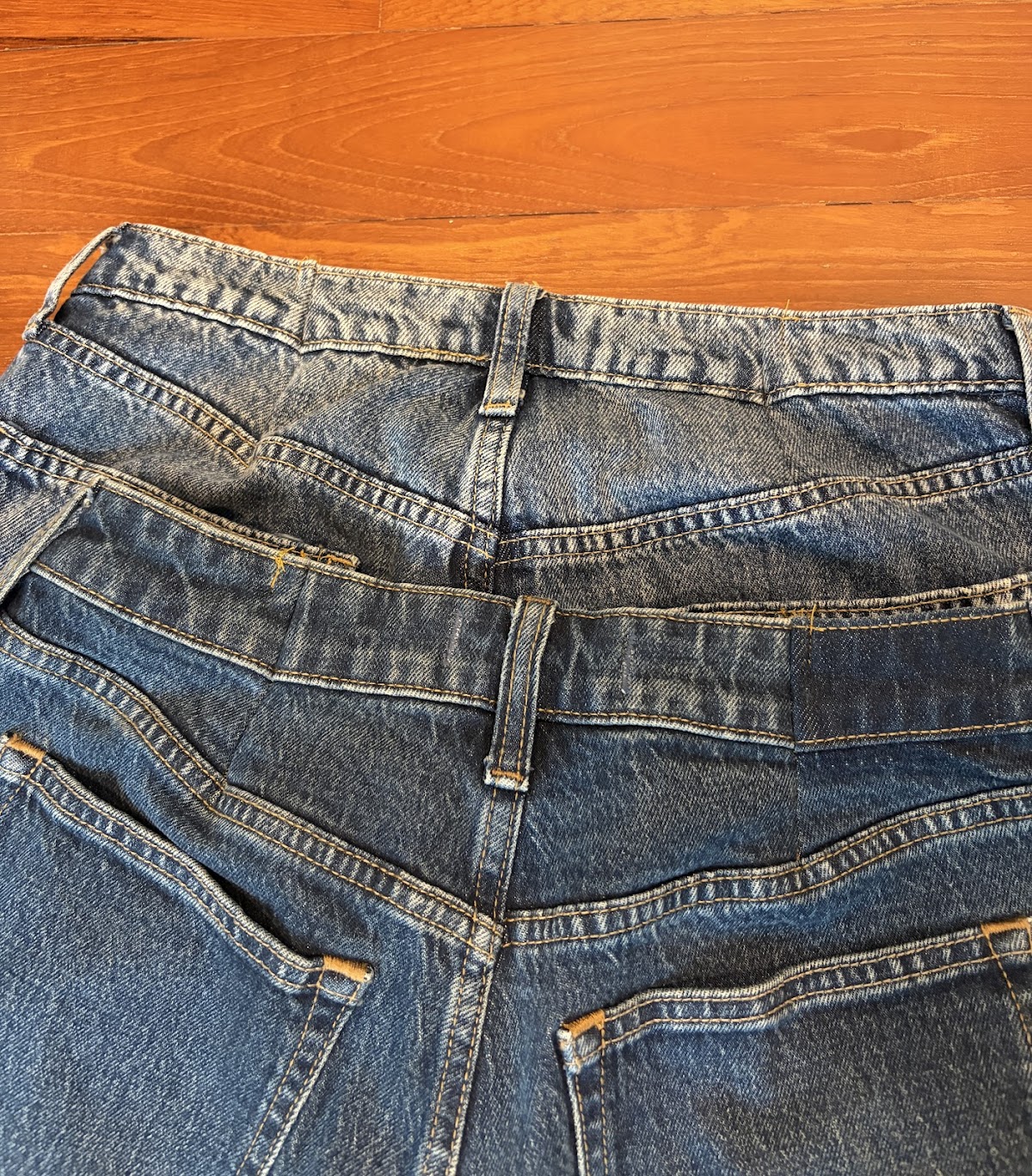 A stack of jeans showing waistband alteration work